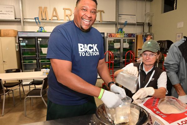 Former Seahawk Red Bryant flashes a big smile as he joins food bank volunteers.